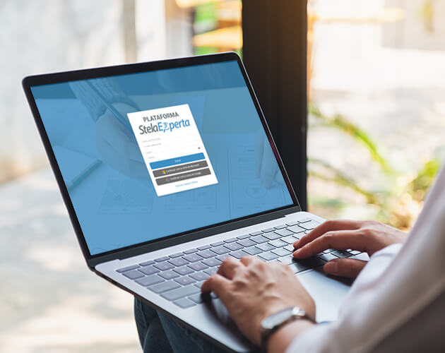 Notebook exibindo a tela de acesso da plataforma Stela Experta